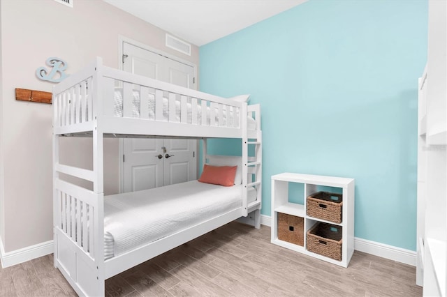 bedroom featuring baseboards, visible vents, and wood finished floors