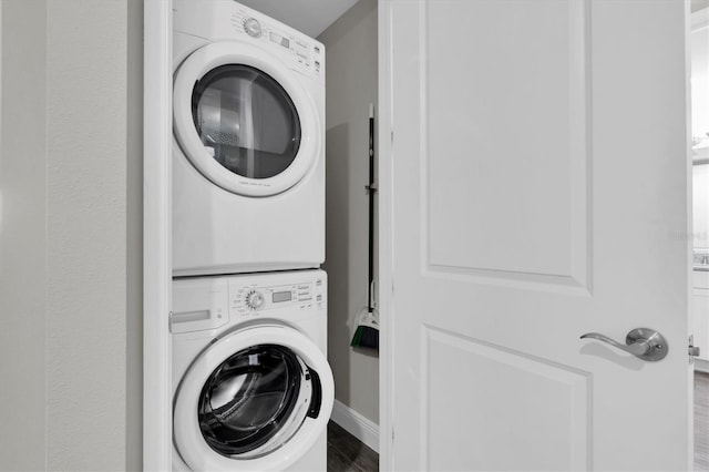 washroom featuring stacked washer / drying machine and laundry area