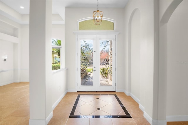 entryway with tile patterned floors, baseboards, arched walkways, and french doors