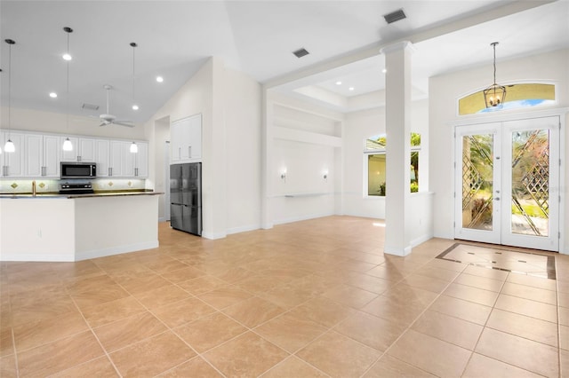 interior space with light tile patterned floors, recessed lighting, visible vents, high vaulted ceiling, and ceiling fan with notable chandelier