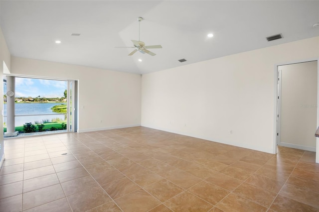 empty room with visible vents, ceiling fan, a water view, vaulted ceiling, and recessed lighting