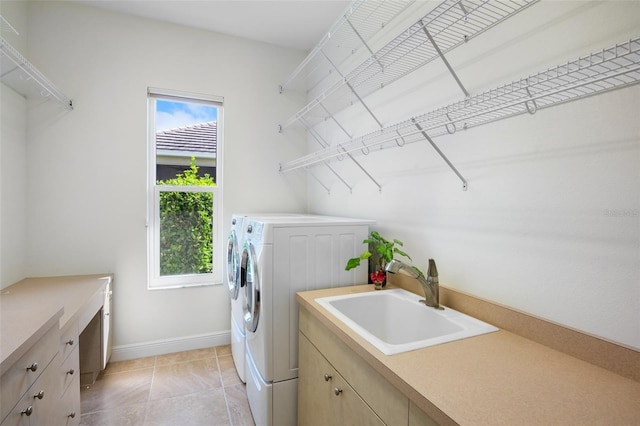 washroom featuring light tile patterned floors, separate washer and dryer, plenty of natural light, and a sink