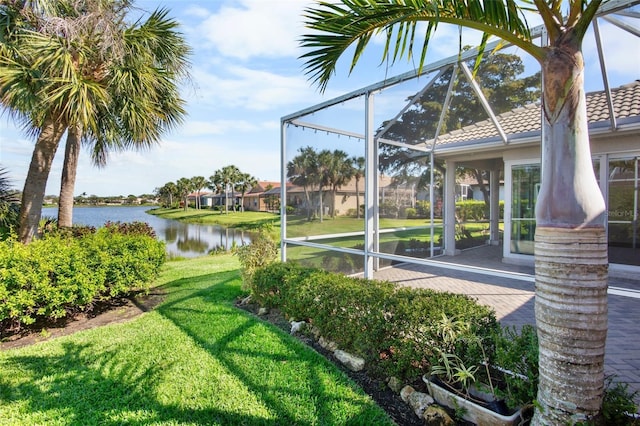 view of yard with a lanai and a water view