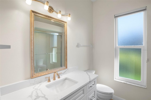 4941 Sabal Lake Cir, Sarasota, FL 34238 - bathroom featuring plenty of natural light, toilet, vanity, and an enclosed shower