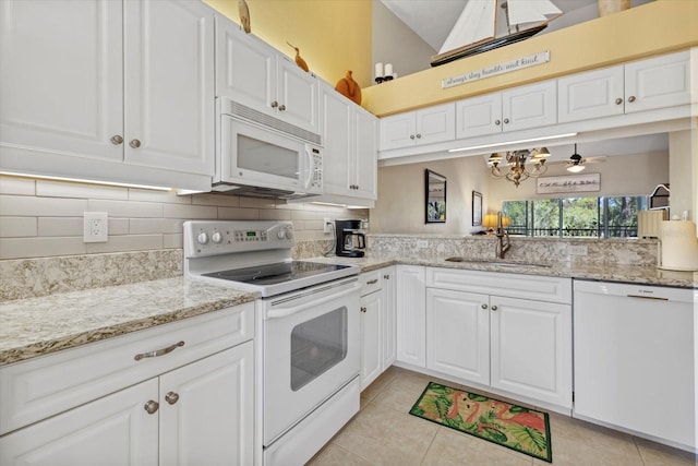 kitchen featuring tasteful backsplash, white appliances, white cabinets, light tile patterned flooring, and sink