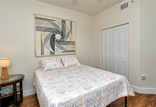 bedroom with baseboards, a closet, visible vents, and dark wood-style flooring