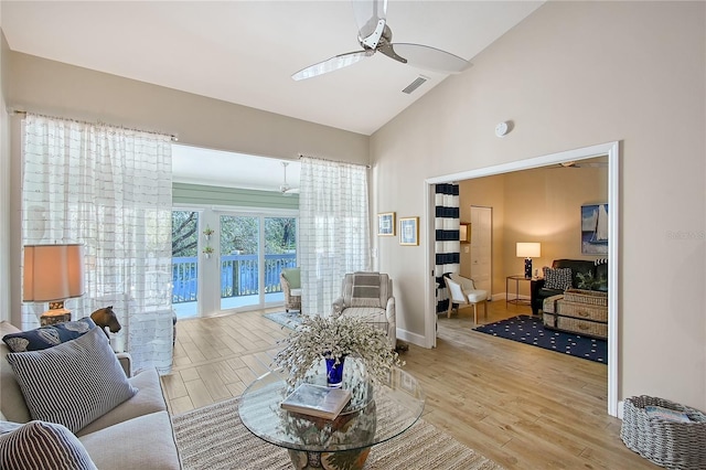 living area featuring visible vents, baseboards, a ceiling fan, and wood finished floors