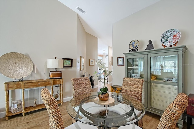 dining area with light wood-type flooring, baseboards, and visible vents