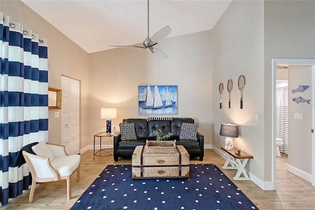 living area featuring high vaulted ceiling, a ceiling fan, and wood finished floors