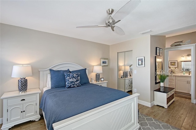 bedroom with ceiling fan, visible vents, baseboards, and wood finished floors