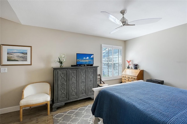 bedroom featuring wood finished floors, baseboards, and ceiling fan