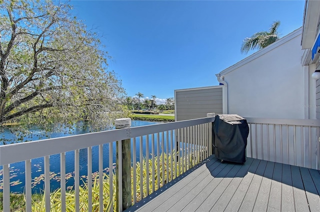 deck with grilling area and a water view