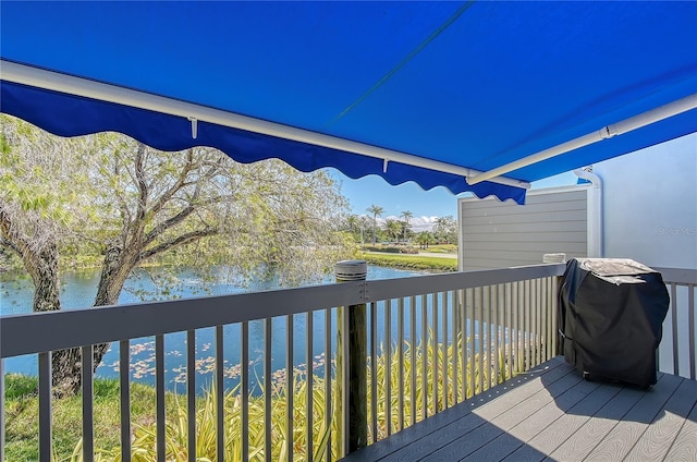 wooden deck with a grill and a water view