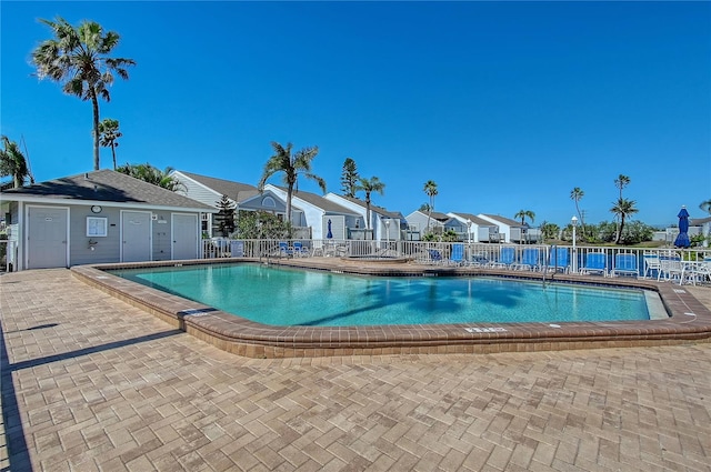 pool featuring a patio area, a residential view, and fence