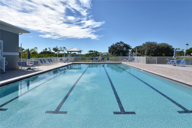 pool with a gazebo, a patio, and fence