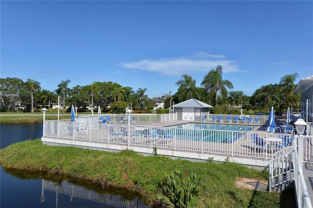 pool featuring a water view, a patio, and fence