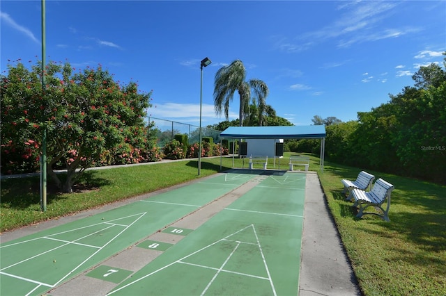 view of home's community featuring shuffleboard and a yard