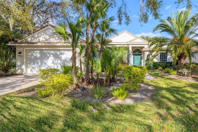 view of front of property with stucco siding, driveway, and a front lawn