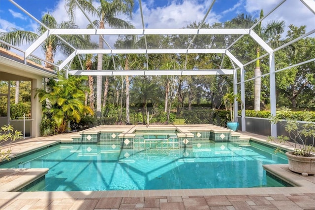 view of pool with glass enclosure, a patio, and a pool with connected hot tub