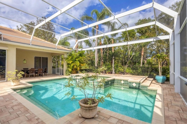 view of swimming pool featuring a patio area, glass enclosure, a pool with connected hot tub, and outdoor dining area