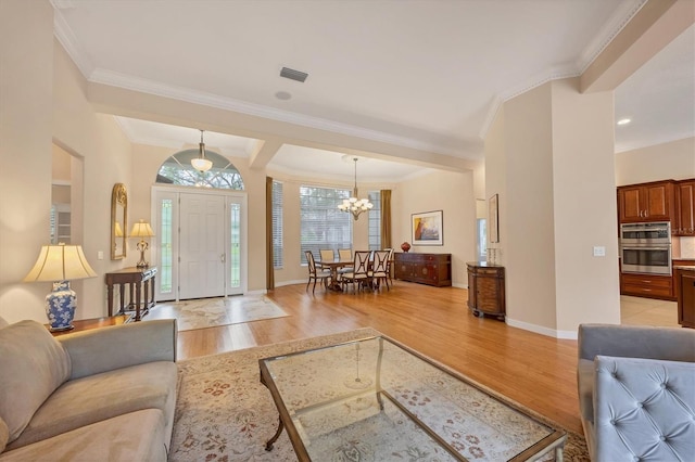 living room featuring baseboards, light wood-style floors, an inviting chandelier, and ornamental molding