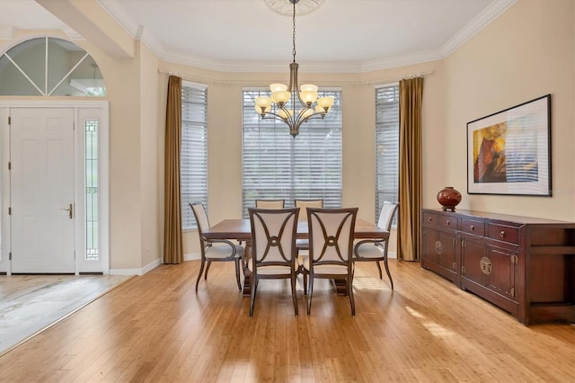 dining space with a chandelier, light wood-style flooring, baseboards, and ornamental molding