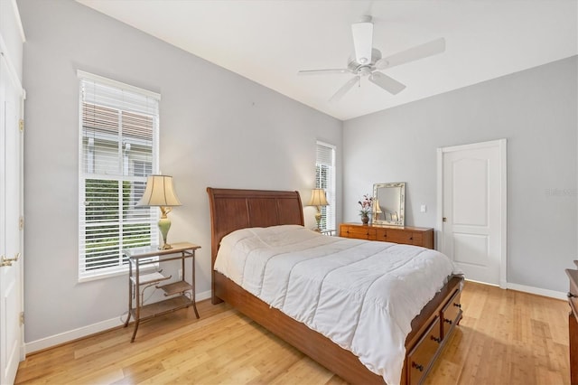 bedroom with a ceiling fan, light wood-type flooring, and baseboards