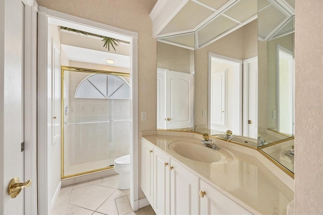 bathroom featuring toilet, a stall shower, vanity, and tile patterned flooring