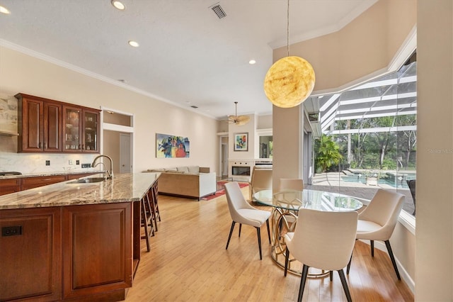 dining space featuring light wood-type flooring, recessed lighting, visible vents, and ornamental molding