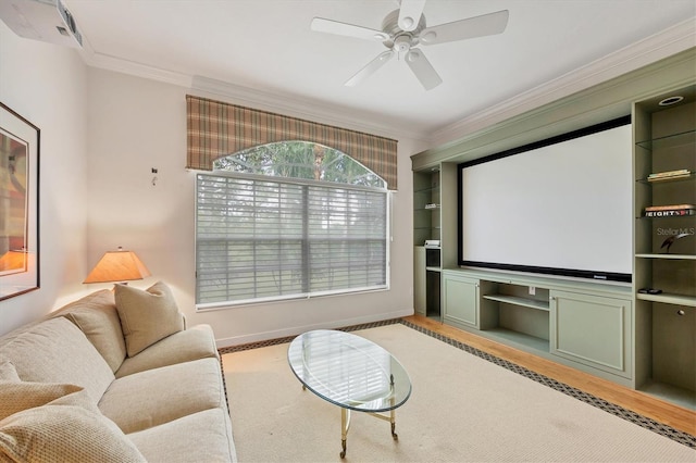 home theater featuring ceiling fan, wood finished floors, and ornamental molding