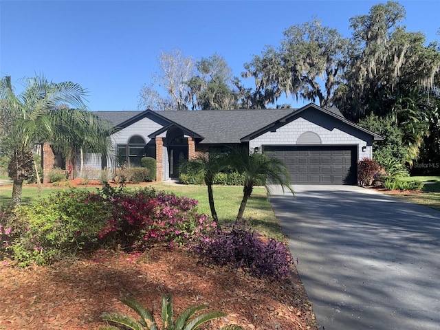 ranch-style home featuring an attached garage, concrete driveway, and roof with shingles