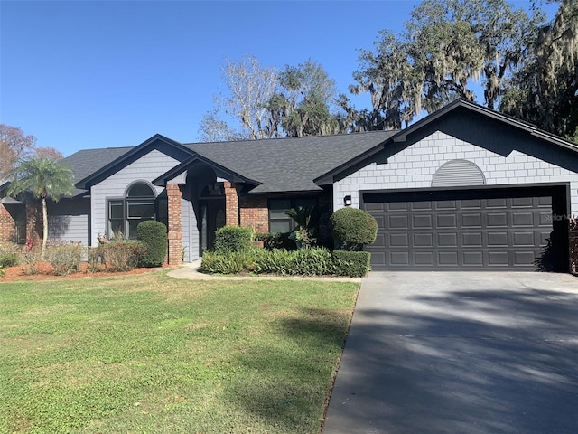 single story home featuring concrete driveway, roof with shingles, an attached garage, a front yard, and brick siding