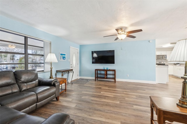 living room with a textured ceiling, hardwood / wood-style flooring, and ceiling fan