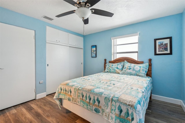 bedroom featuring ceiling fan, dark hardwood / wood-style floors, and a closet