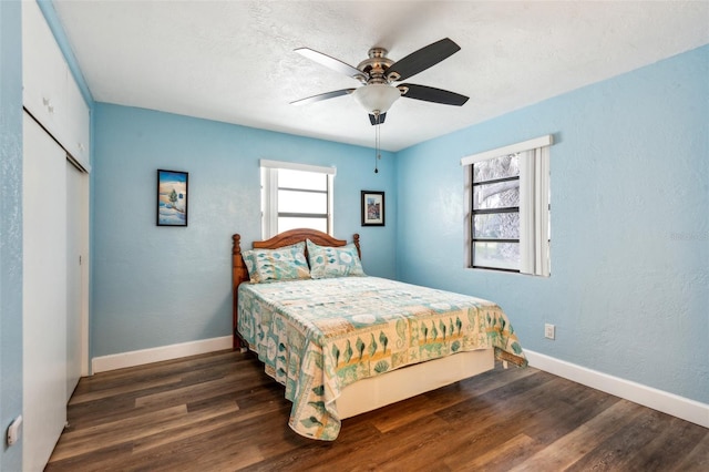 bedroom with dark hardwood / wood-style flooring, ceiling fan, and a closet