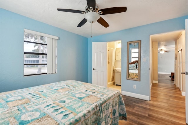 bedroom featuring hardwood / wood-style flooring, ceiling fan, and connected bathroom