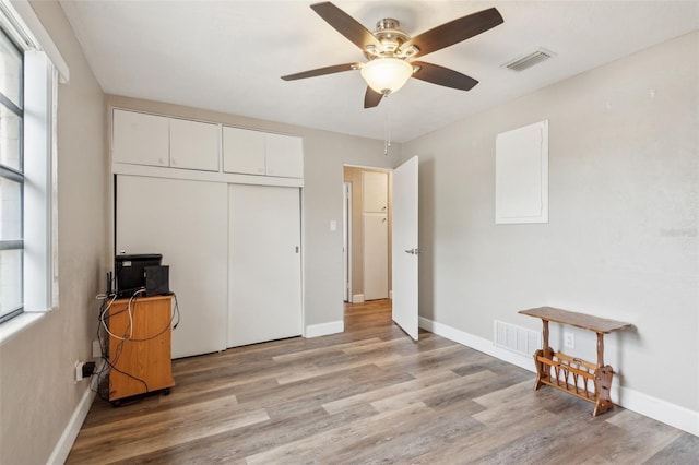 bedroom with multiple windows, a closet, ceiling fan, and light hardwood / wood-style floors