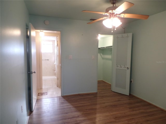 unfurnished bedroom with dark hardwood / wood-style flooring, ceiling fan, a closet, and a spacious closet