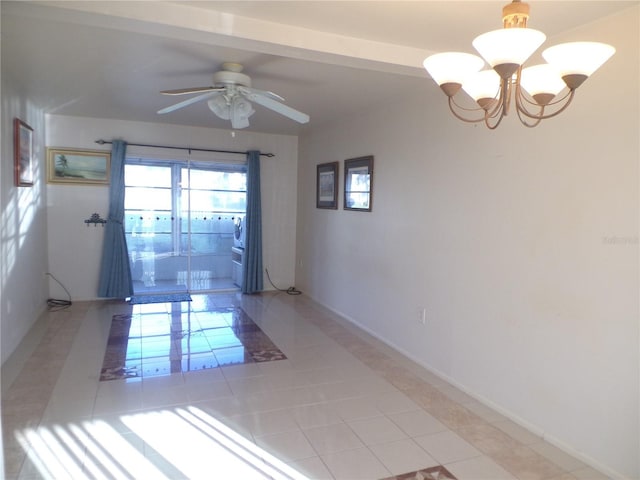 tiled empty room featuring ceiling fan with notable chandelier