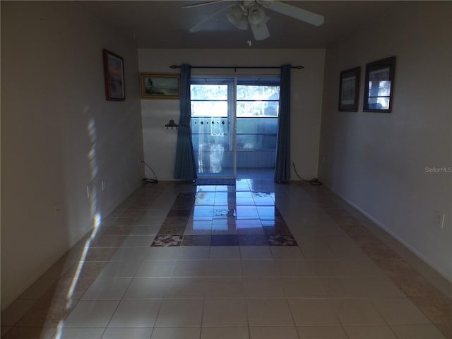 doorway with ceiling fan and tile patterned floors