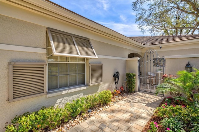 entrance to property with a gate and stucco siding