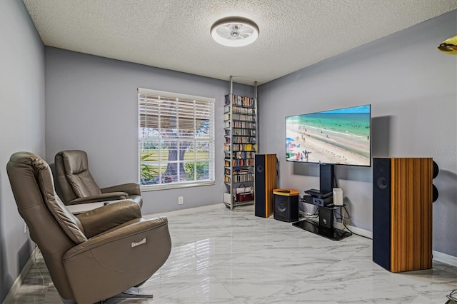 sitting room featuring marble finish floor, a textured ceiling, and baseboards