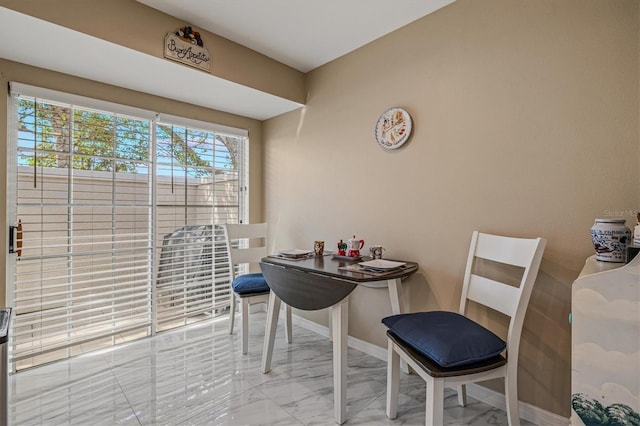 dining area with marble finish floor and baseboards