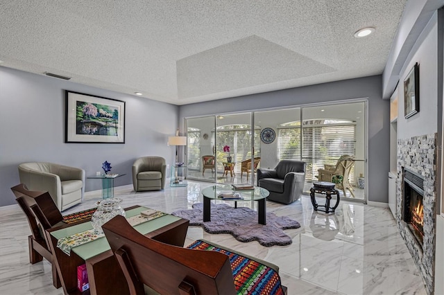 living room featuring plenty of natural light, marble finish floor, and a fireplace