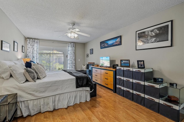 bedroom with light wood finished floors, ceiling fan, and a textured ceiling