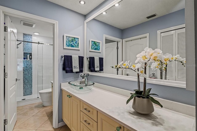 bathroom with visible vents, toilet, a stall shower, vanity, and tile patterned flooring