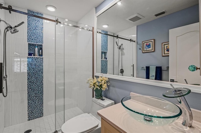 bathroom featuring toilet, a stall shower, visible vents, and vanity