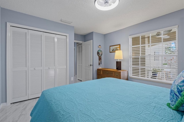 bedroom with a closet, visible vents, and a textured ceiling