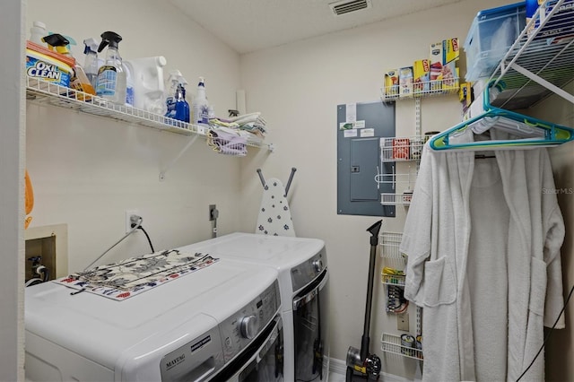 washroom featuring washing machine and dryer, laundry area, visible vents, and electric panel