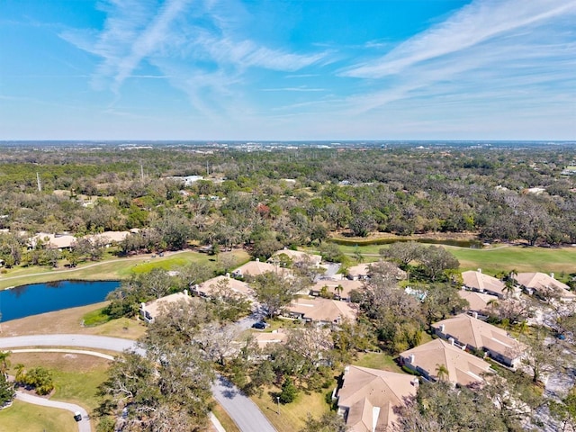 drone / aerial view featuring a water view, a wooded view, and a residential view